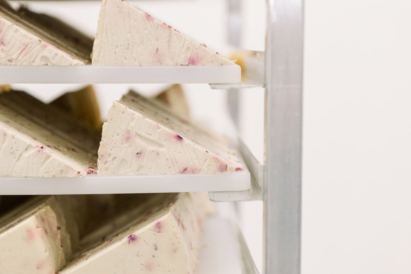 Les cales fraîches, sans produits laitiers, biologiques Nuts For Cheese™ sur un rayonnage d'usine après avoir été fabriquées.