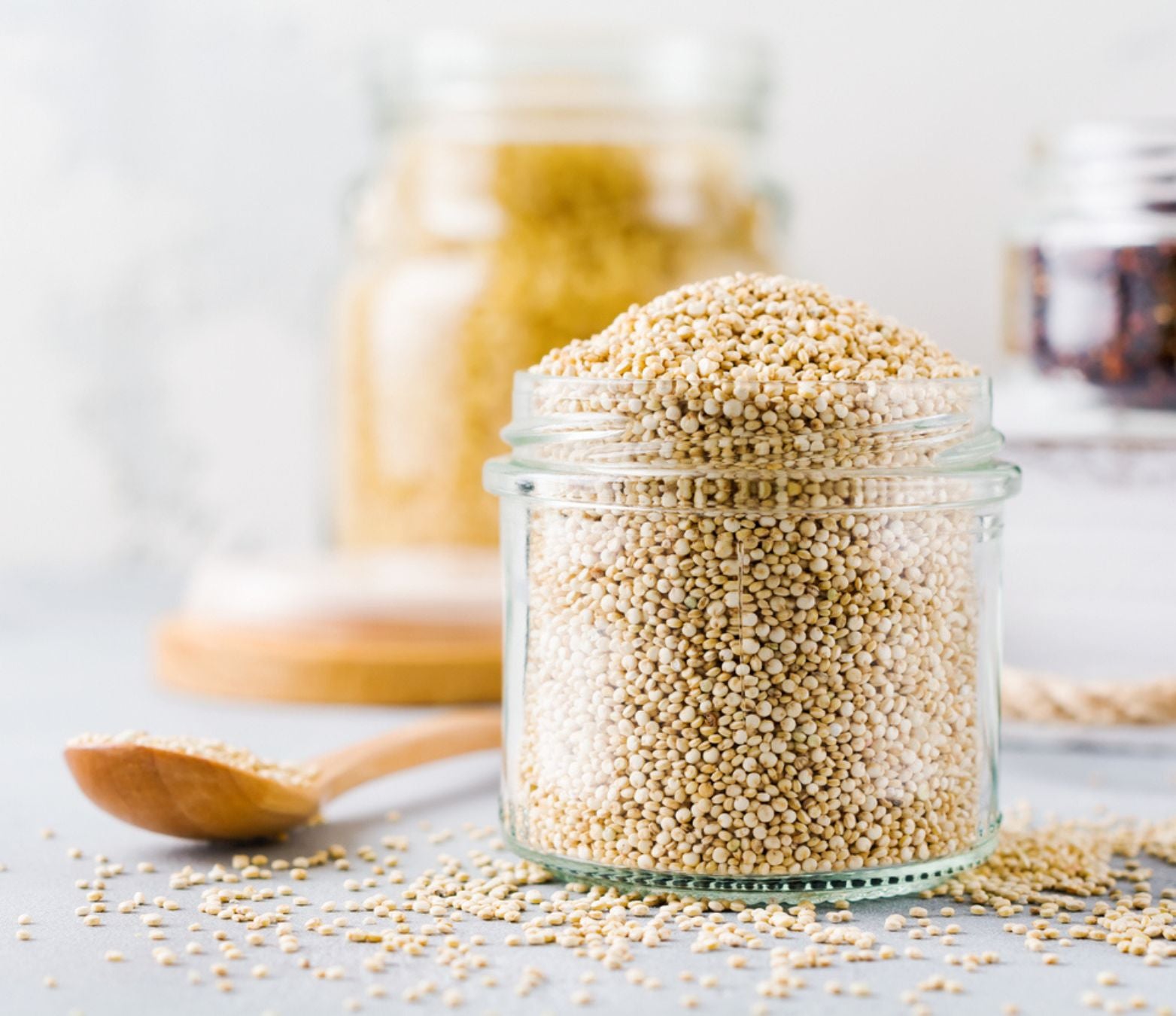 organic quinoa rejuvelac in a clear jar and a wooden spoon on a table