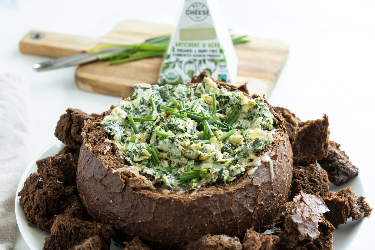 Bread bowl stuffed with vegan spinach dip made from dairy-free artichoke & herb cheese. 