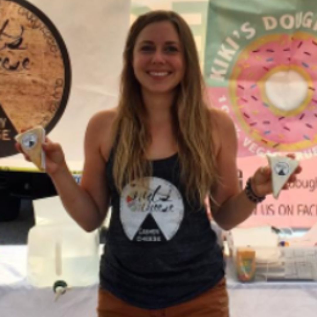 Margaret Coons holding wedges of dairy free Nuts For Cheese at an early London Farmer's Market event.