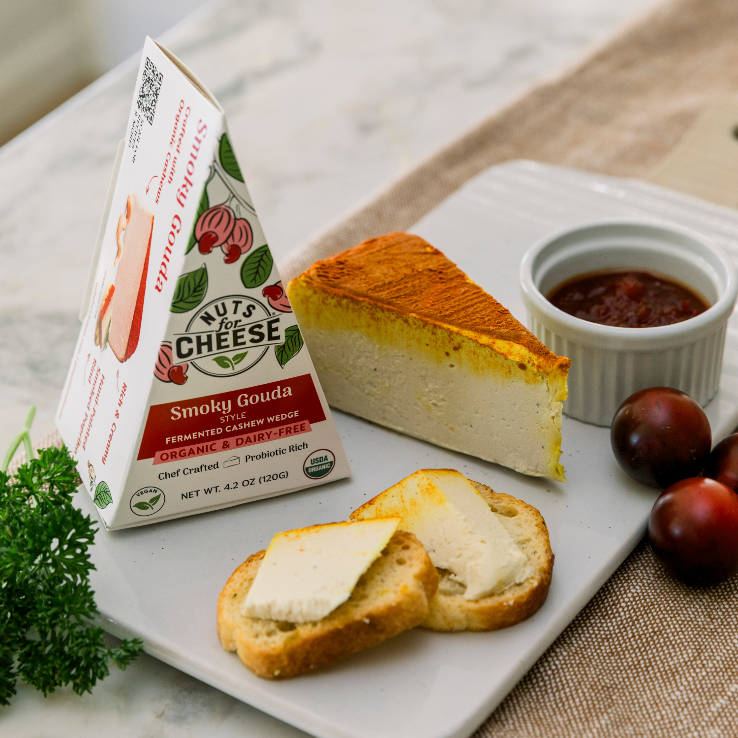 Tranche de fromage de cajou Smoky Gouda sur une assiette avec du pain et du fromage.