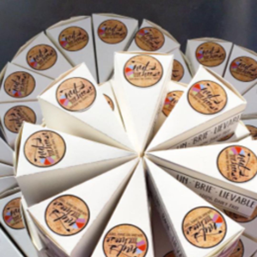 Wedges of Nuts For Cheese dairy free cheese in first packaging arranged in a wheel format.