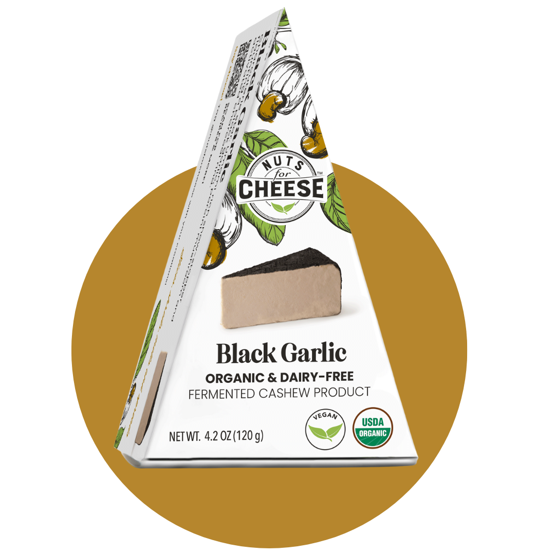Nuts For Cheese™ Organic & dairy-free fermented Black Garlic cheese wedge package on a gold circle background