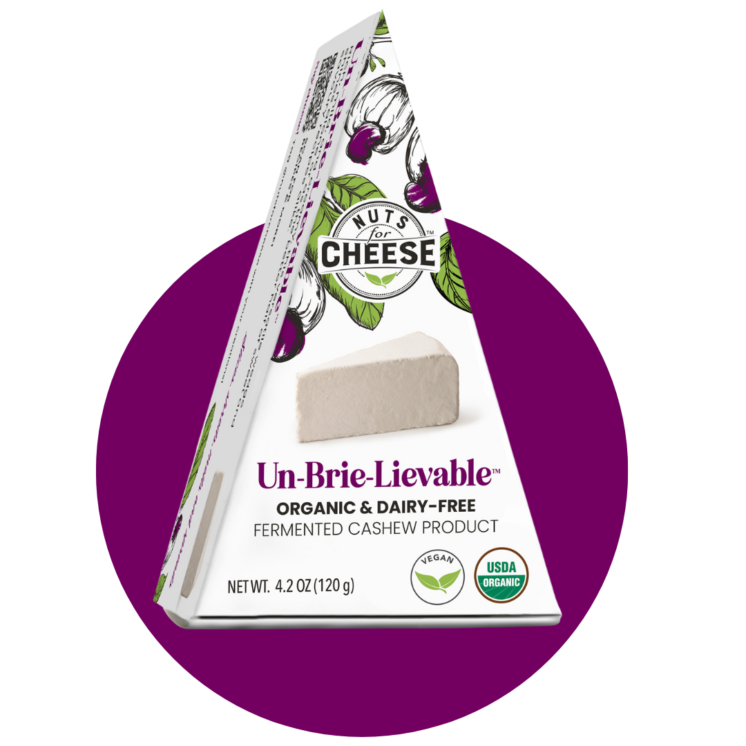 Nuts For Cheese™ Organic & dairy-free fermented Un-Brie-Lievable™ Brie cheese wedge package on a purple circle background